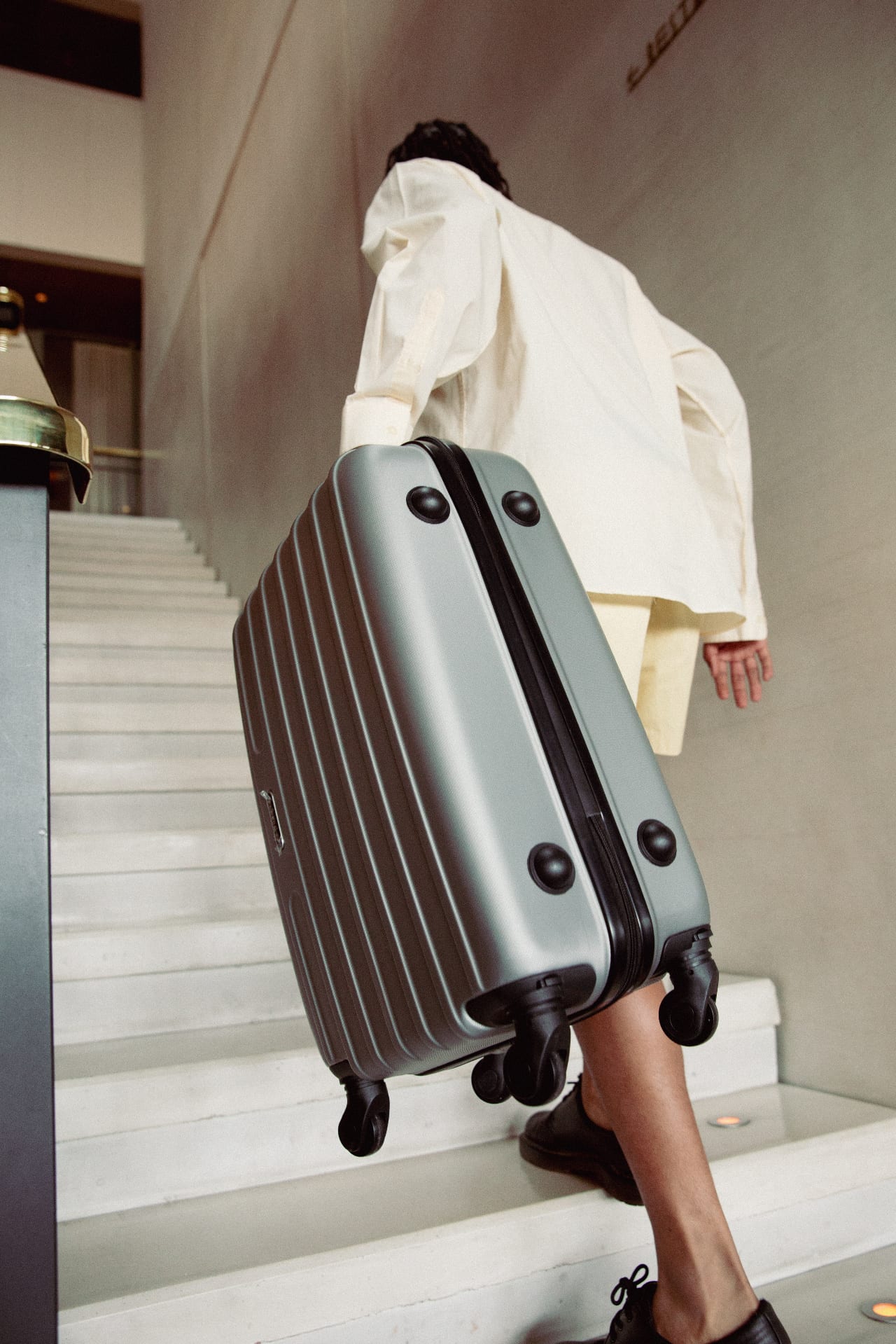 Llegada a un hotel: maleta junto a la escalera