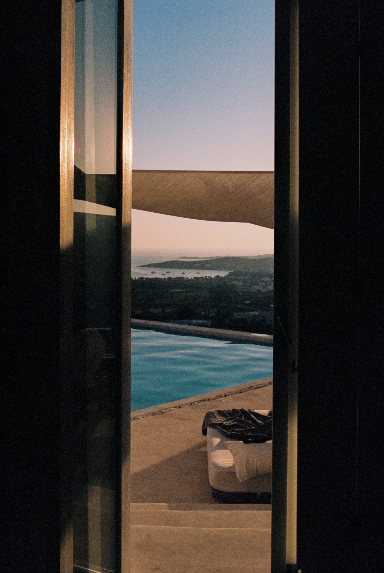 Vista al mar desde la ventana de un hotel al atardecer